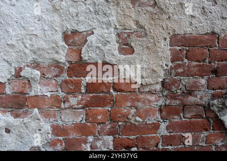 Mur de briques rouges avec des restes de ciment, ciment, mortier. Fond de construction brutale. Banque D'Images