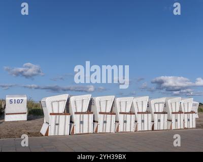 Chaises de plage blanches sur une prairie et ciel bleu avec des nuages en arrière-plan, le long de la côte de la mer des Wadden classée au patrimoine mondial de l'UNESCO, Buesum, mer du Nord Banque D'Images