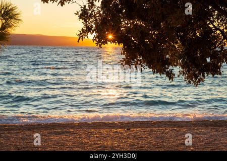 Coucher de soleil sur la plage de galets à Brela, Croatie Banque D'Images