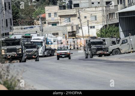 Jénine, Palestine. 09 novembre 2024. Des véhicules militaires israéliens ont encerclé une maison habitée par un palestinien et fermé la rue lors d'un raid visant à arrêter un palestinien dans le village d'Aqaba, au sud de la ville de Djénine, dans le nord de la Cisjordanie. Des affrontements ont éclaté pendant des heures entre Palestiniens et forces israéliennes, entraînant la mort d'un palestinien dont le corps avait été détenu par l'armée et la blessure d'un autre lors d'une opération militaire menée par les forces israéliennes. (Photo de Nasser Ishtayeh/SOPA images/Sipa USA) crédit : Sipa USA/Alamy Live News Banque D'Images