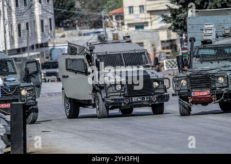 Jénine, Palestine. 09 novembre 2024. Des véhicules militaires israéliens ont encerclé une maison habitée par un palestinien et fermé la rue lors d'un raid visant à arrêter un palestinien dans le village d'Aqaba, au sud de la ville de Djénine, dans le nord de la Cisjordanie. Des affrontements ont éclaté pendant des heures entre Palestiniens et forces israéliennes, entraînant la mort d'un palestinien dont le corps avait été détenu par l'armée et la blessure d'un autre lors d'une opération militaire menée par les forces israéliennes. (Photo de Nasser Ishtayeh/SOPA images/Sipa USA) crédit : Sipa USA/Alamy Live News Banque D'Images