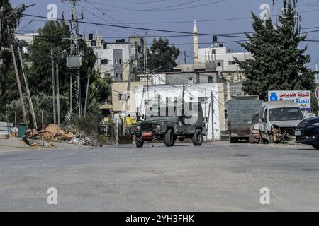 Jénine, Palestine. 09 novembre 2024. Des véhicules militaires israéliens ont encerclé une maison habitée par un palestinien et fermé la rue lors d'un raid visant à arrêter un palestinien dans le village d'Aqaba, au sud de la ville de Djénine, dans le nord de la Cisjordanie. Des affrontements ont éclaté pendant des heures entre Palestiniens et forces israéliennes, entraînant la mort d'un palestinien dont le corps avait été détenu par l'armée et la blessure d'un autre lors d'une opération militaire menée par les forces israéliennes. (Photo de Nasser Ishtayeh/SOPA images/Sipa USA) crédit : Sipa USA/Alamy Live News Banque D'Images