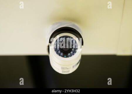Gros plan d'une caméra de sécurité installée sur un plafond pour la surveillance dans une installation. Banque D'Images