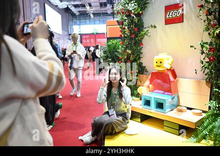 Shanghai, CIIE dans l'est de la Chine Shanghai. 9 novembre 2024. Un visiteur pose pour des photos sur le stand du groupe LEGO, participant à plein temps à la China International Import Expo (CIIE), lors de la 7e CIIE à Shanghai, dans l'est de la Chine, le 9 novembre 2024. Du 5 au 10 novembre, le 7ème CIIE a attiré 3 496 exposants de 129 pays et régions. Parmi tous les participants, 186 entreprises et institutions ont atteint la pleine participation dans les sept éditions de l'expo, tandis que beaucoup d'autres sont de nouveaux visages exposant pour la première fois. Crédit : Chen Haoming/Xinhua/Alamy Live News Banque D'Images