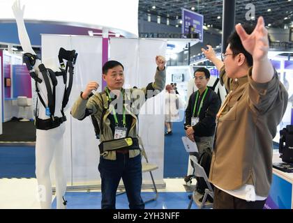 Shanghai. 9 novembre 2024. Les visiteurs essaient un exosquelette à la section spéciale incubation lors de la 7e exposition internationale d'importation de Chine (CIIE) à Shanghai, dans l'est de la Chine, le 9 novembre 2024. Avec le thème « franchir les frontières, incuber les forces innovantes et diriger les technologies du futur », la section spéciale incubation du 7e CIIE vise à offrir aux incubateurs technologiques l'opportunité d'explorer conjointement les voies de l'innovation. Crédit : Xu Liang/Xinhua/Alamy Live News Banque D'Images