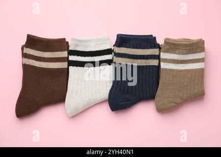 Différentes chaussettes confortables sur fond rose clair, pose plate Banque D'Images
