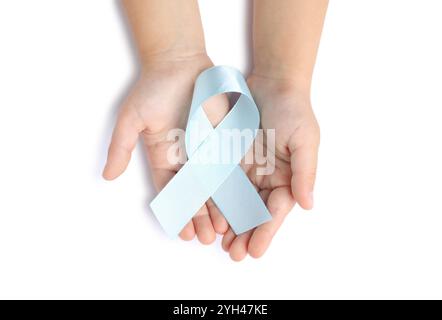 Enfant avec ruban bleu clair sur fond blanc, vue de dessus. Sensibilisation au cancer de l'enfant Banque D'Images