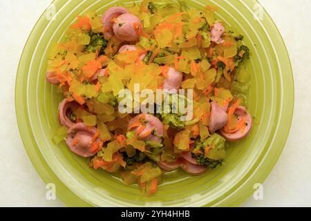 Vue de dessus d'une assiette avec ragoût de légumes de brocoli, courgettes, carottes et saucisses. Cuisine domestique. Banque D'Images