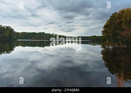 Un étang de réservoir lisse vitreux permet aux beaux arbres d'automne le long de la rive de jeter un reflet étonnant sur l'eau. Banque D'Images