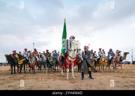 Les cavaliers saoudiens de chameaux avec leurs chameaux participent à un festival traditionnel de safari dans le désert à Abqaiq, en Arabie saoudite, le 10 janvier 2020. Banque D'Images