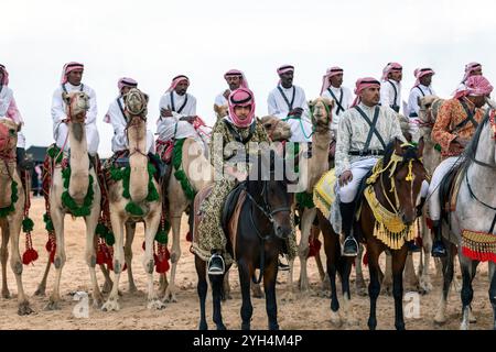 Les cavaliers saoudiens de chameaux avec leurs chameaux participent à un festival traditionnel de safari dans le désert à Abqaiq, en Arabie saoudite, le 10 janvier 2020. Banque D'Images