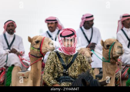 Les cavaliers saoudiens de chameaux avec leurs chameaux participent à un festival traditionnel de safari dans le désert à Abqaiq, en Arabie saoudite, le 10 janvier 2020. Banque D'Images