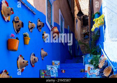 Maisons et rues bleues avec souvenirs touristiques exposés à la vente à Chefchaouen, Maroc. Banque D'Images