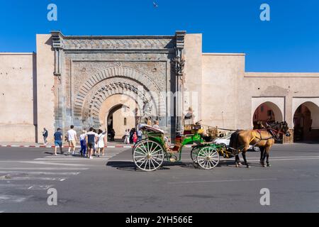 Une calèche tirée par des chevaux et des touristes devant la porte de Bab Agnaou à Marrakech, Maroc. Banque D'Images