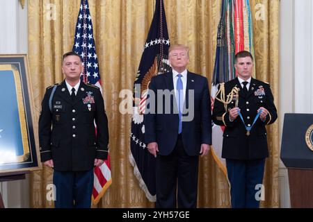 Washington, États-Unis d'Amérique. 25 juin 2019. U. Le président Donald Trump, au centre, écoute la citation avant de remettre la médaille d'honneur au sergent d'état-major de l'armée américaine à la retraite David Bellavia, à gauche, lors d'une cérémonie dans la salle est de la Maison Blanche, le 25 juin 2019 à Washington, DC. Bellavia a reçu le plus grand honneur des Nations pour ses actions lors de la deuxième bataille de Falloujah. Crédit : Shealah Craighead/White House photo/Alamy Live News Banque D'Images