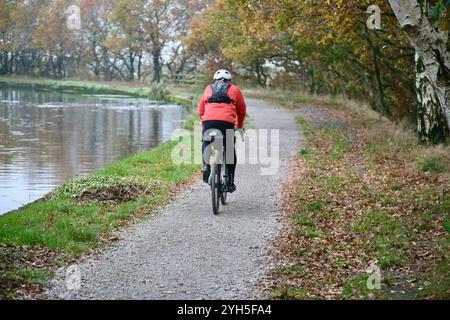 Un cycliste sur le chemin de halage, du canal Leeds Liverpool, Red Rock, Wigan, Lancashire, Royaume-Uni, L'Europe à l'automne 2024. Banque D'Images