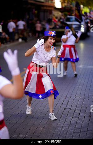 Des danseurs vêtus de tenues américaines se battent sur le thème du samedi lors de la parade du jour des vétérans militaires américains le long de Houston dans le centre-ville de San Antonio. Banque D'Images