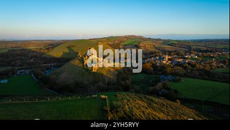 Vue aérienne du coucher du soleil du château de Corfe, un village et une paroisse civile dans le comté anglais du Dorset Banque D'Images