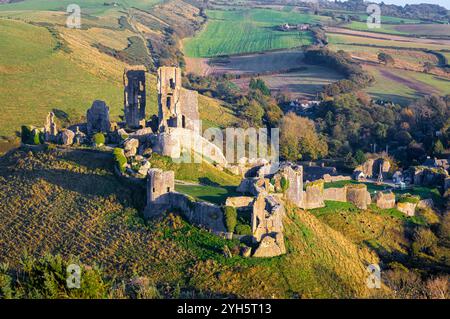 Vue aérienne du coucher du soleil du château de Corfe, un village et une paroisse civile dans le comté anglais du Dorset Banque D'Images