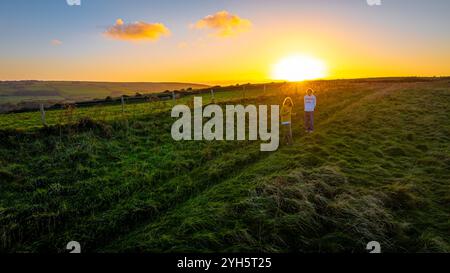 Vue aérienne du coucher du soleil du château de Corfe, un village et une paroisse civile dans le comté anglais du Dorset Banque D'Images