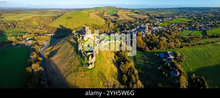 Vue aérienne du coucher du soleil du château de Corfe, un village et une paroisse civile dans le comté anglais du Dorset Banque D'Images