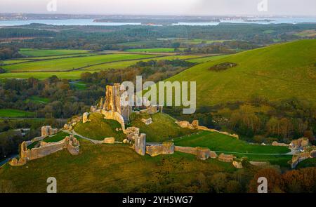 Vue aérienne du coucher du soleil du château de Corfe, un village et une paroisse civile dans le comté anglais du Dorset Banque D'Images