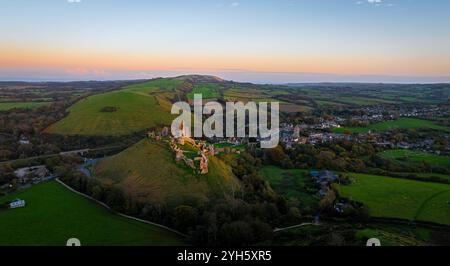 Vue aérienne du coucher du soleil du château de Corfe, un village et une paroisse civile dans le comté anglais du Dorset Banque D'Images