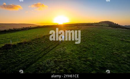 Vue aérienne du coucher du soleil du château de Corfe, un village et une paroisse civile dans le comté anglais du Dorset Banque D'Images