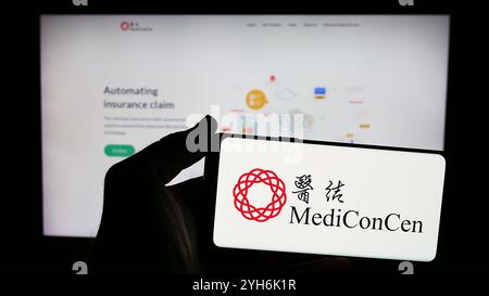 Allemagne. 8 juillet 2024. Dans cette illustration photo, un homme tient un smartphone avec le logo de la compagnie d’assurance blockchain Mediconcen Limited en face du site web. (Crédit image : © timon Schneider/SOPA images via ZUMA Press Wire) USAGE ÉDITORIAL SEULEMENT ! Non destiné à UN USAGE commercial ! Banque D'Images