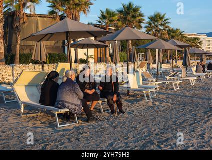 Groupe de femmes âgées se reposant sur la plage parlant. Amis matures se relaxant sur la plage ayant une conversation. Les aînés socialisent. Albanie, novembre Banque D'Images