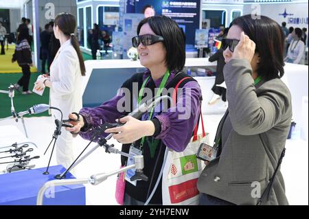 Shanghai. 9 novembre 2024. Les visiteurs font l'expérience d'un système chirurgical robotique lors de la 7e exposition internationale d'importation de Chine (CIIE) à Shanghai, dans l'est de la Chine, le 9 novembre 2024. Le 7e CIIE s’est tenu ici du 5 au 10 novembre. De nombreux exposants ont offert diverses activités interactives pour que les visiteurs se familiarisent avec leurs produits et services. Crédit : Huang Xiaoyong/Xinhua/Alamy Live News Banque D'Images