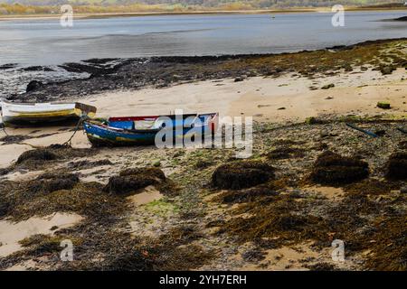 Deux bateaux à rames attendent la marée haute sur la rivière Conwy près du château de Conwy, prise le 26 octobre 2024. Banque D'Images