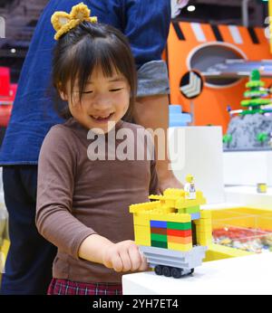 Shanghai. 9 novembre 2024. Une fille s'amuse avec des briques Lego lors de la 7ème China International Import Expo (CIIE) à Shanghai, dans l'est de la Chine, le 9 novembre 2024. Le 7e CIIE s’est tenu ici du 5 au 10 novembre. De nombreux exposants ont offert diverses activités interactives pour que les visiteurs se familiarisent avec leurs produits et services. Crédit : Liu Qian/Xinhua/Alamy Live News Banque D'Images