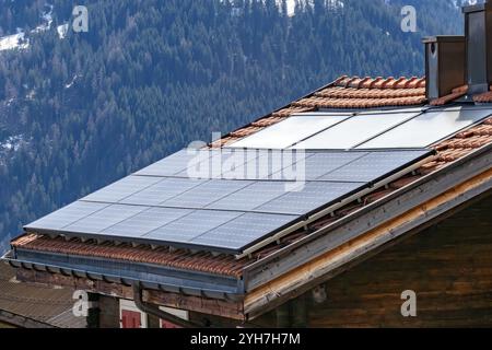 Capteurs solaires sur une vieille maison en bois en Suisse Banque D'Images