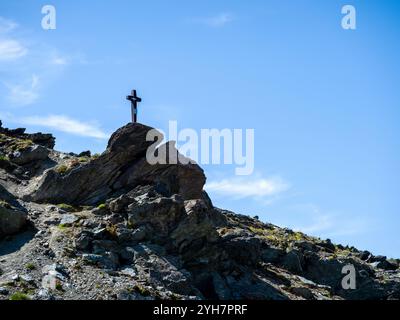 Croix noire debout sur le dessus de la formation rocheuse de falaise sur fond de ciel bleu avec espace de copie. Silhouettes de croix debout sur la falaise, au tra touristique Banque D'Images