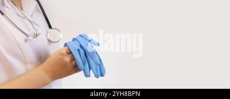 Médecin avec stéthoscope et gants dans les mains. Médecine et concept de santé. Pédiatre en manteau blanc. Médecin féminin, fond blanc. Copier l'espace. FAM Banque D'Images