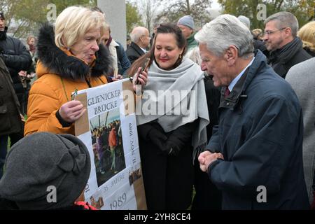 10 novembre 2024, Brandebourg, Potsdam : mariage Klinkmüller, témoin contemporain, tient une photographie la montrant traverser le pont de Glienicke en 1989 et s'entretient avec la ministre de la culture du Brandebourg Manja Schüle et Joachim Gauck, ancien président fédéral, (gauche-droite) lors de l'événement commémoratif marquant l'ouverture du pont de Glienicke en 1989. Il y a 35 ans aujourd'hui, les citoyens de la RDA ont pu franchir le pont vers Berlin-Ouest sans formalités pour la première fois. L'événement commémoratif est organisé par le Fördergemeinschaft Lindenstraße 54 et la capitale de l'État, Potsdam. Photo : Michael Bahlo/dpa Banque D'Images