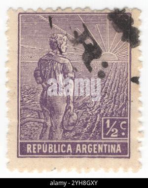 ARGENTINE - 1911 : timbre-poste violet ½ centavo représentant un ouvrier agricole, composition allégorique Agriculture. Un jeune agriculteur avec une charrue au bord d'un champ partiellement labouré regarde le lever du soleil. Un symbole de la réforme agricole et de la formation de l'Argentine comme puissance mondiale dans la production agricole Banque D'Images