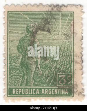 ARGENTINE - 1911 : timbre-poste vert à 3 centavos représentant un ouvrier agricole, composition allégorique Agriculture. Un jeune agriculteur avec une charrue au bord d'un champ partiellement labouré regarde le lever du soleil. Un symbole de la réforme agricole et de la formation de l'Argentine comme puissance mondiale dans la production agricole Banque D'Images