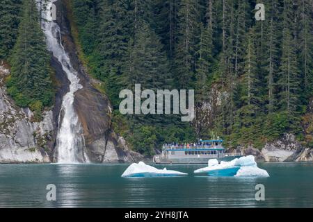 Alaska, Tongas Forest, Tracy Arm. Bateau de tourisme explorant la côte isolée avec cascade. Banque D'Images