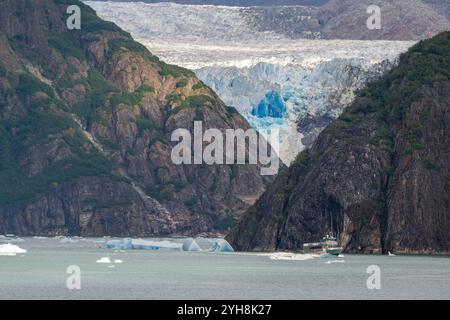 Alaska, Tongas Forest, Tracy Arm. Bateau touristique explorant la côte reculée, glacier au loin. Banque D'Images