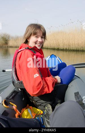 Jeune femme en canoë gonflable Sevylor Colorado Premium dans les bas-fonds d'Surlingham large, près de Norwich, Norfolk Broads, Parc National Banque D'Images