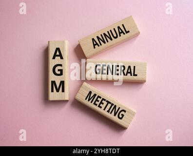 AGA - symbole de l'Assemblée générale annuelle. Mot concept AGM sur des blocs de bois. Beau fond rose. Business et AGM concept. Copier l'espace. Banque D'Images