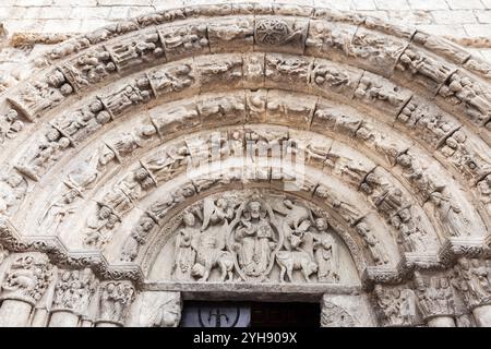 Des sculptures en pierre détaillées représentent des scènes bibliques et des figures au-dessus de l'entrée d'une ancienne église. Banque D'Images