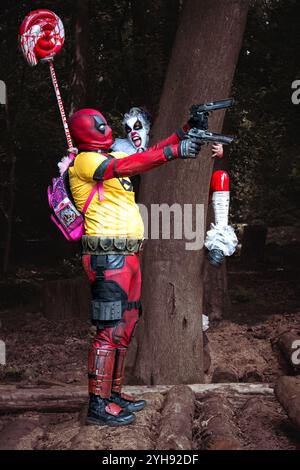 HARROGATE, ROYAUME-UNI - 22 JUIN 2024. Une paire de cosplayers drôles habillés en Deadpool et Pennywise le Clown s'amusant et étant stupide à un Comic Con Banque D'Images