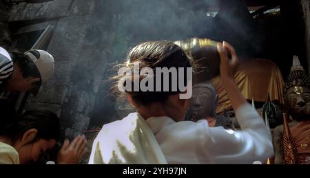 Laos, Champasak, Wat Phu : le festival annuel Wat Phu Champasak attire des gens et des moines de tout le Laos. Une femme soulève une pierre dans la dévotion pendant Banque D'Images