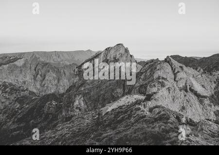 Un groupe de randonneurs naviguant sur un sentier de montagne accidenté sur Madère, entouré de paysages rocheux spectaculaires. Banque D'Images