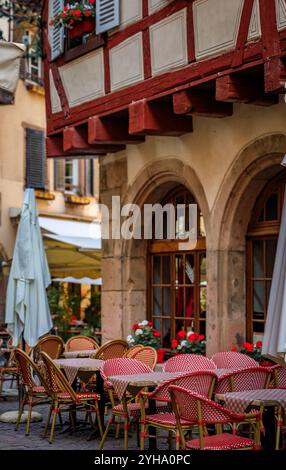 Tables extérieures au restaurant winstub alsacien dans une maison traditionnelle à colombages à Colmar, un village pittoresque d'Alsace, France Banque D'Images