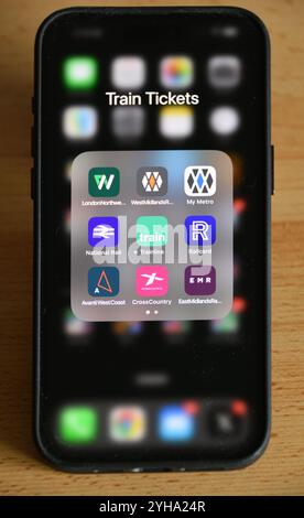 UK smartphone sur la table avec des applications de billets de train dans un dossier pour les compagnies d'exploitation de train, National Rail, Railcard et le Trainline.com Banque D'Images