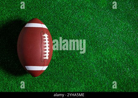 Un ballon de football américain est sur un terrain vert vu d'en haut. Banque D'Images